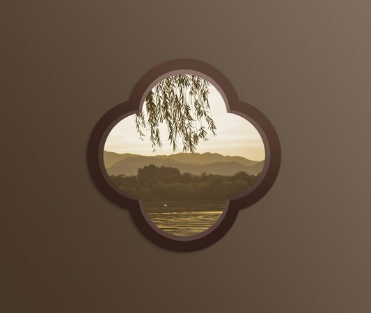 A quatrefoil garden window set into a courtyard wall, framing willow branches, a lake and distant hills at dusk
