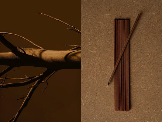 A bare wooden branch beside a bundle of solid brown natural incense sticks laid on kraft paper, showing the raw material and the finished stick