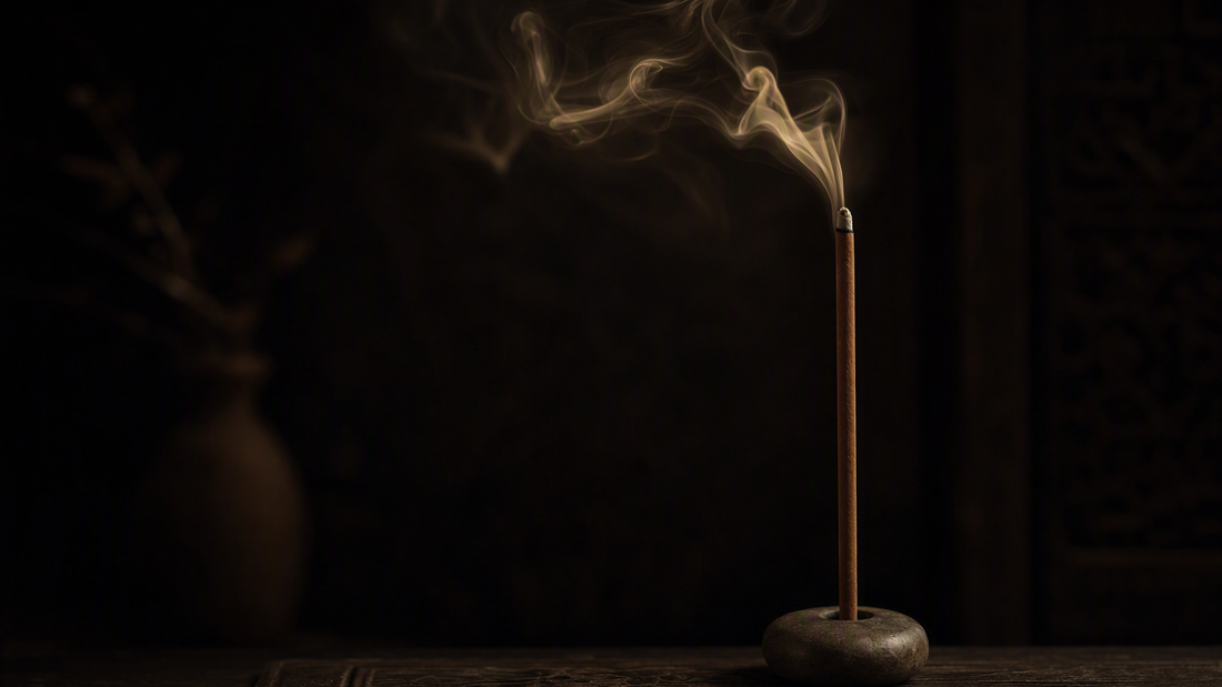 Incense stick burning down slowly in a moody dark setting
