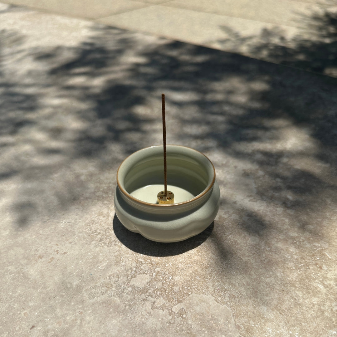 Ru Ware Lotus Incense Burner - Celadon Cream on stone surface with incense stick
