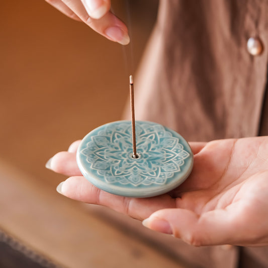 Blooming Lotus Incense Disc in celadon ceramic held in hand showing raised lotus relief