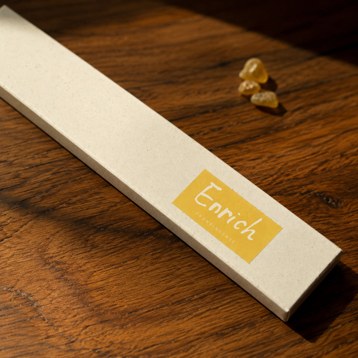 Close-up of the Enrich Frankincense Incense label on its paper box in warm light